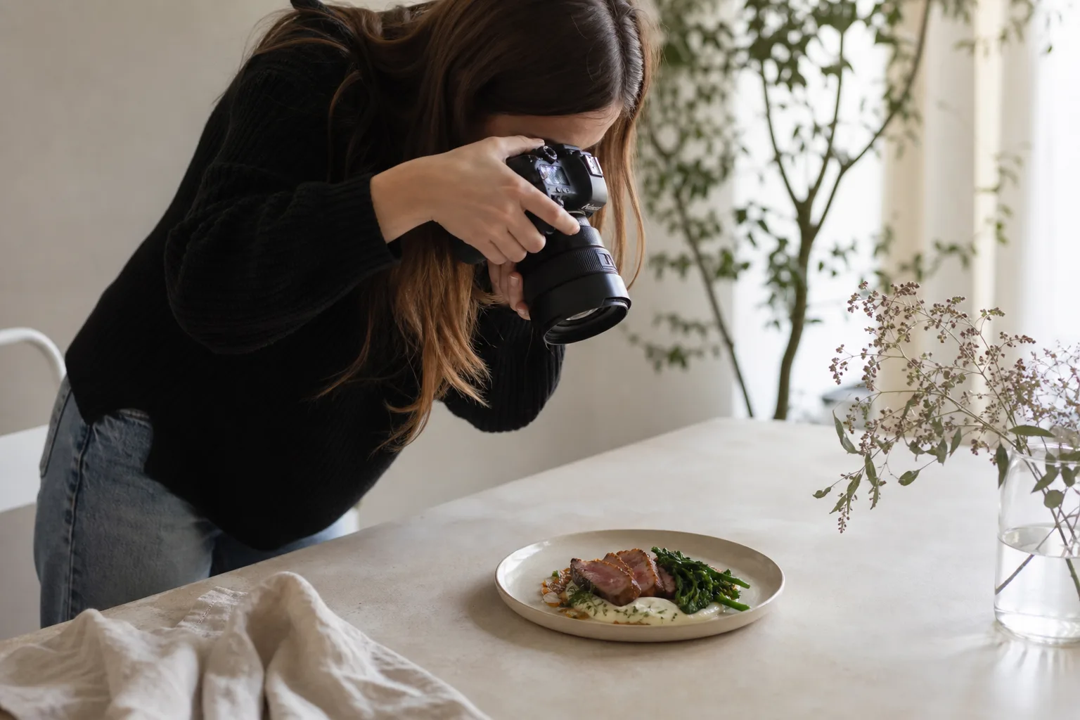 a woman taking a picture of food on a plate