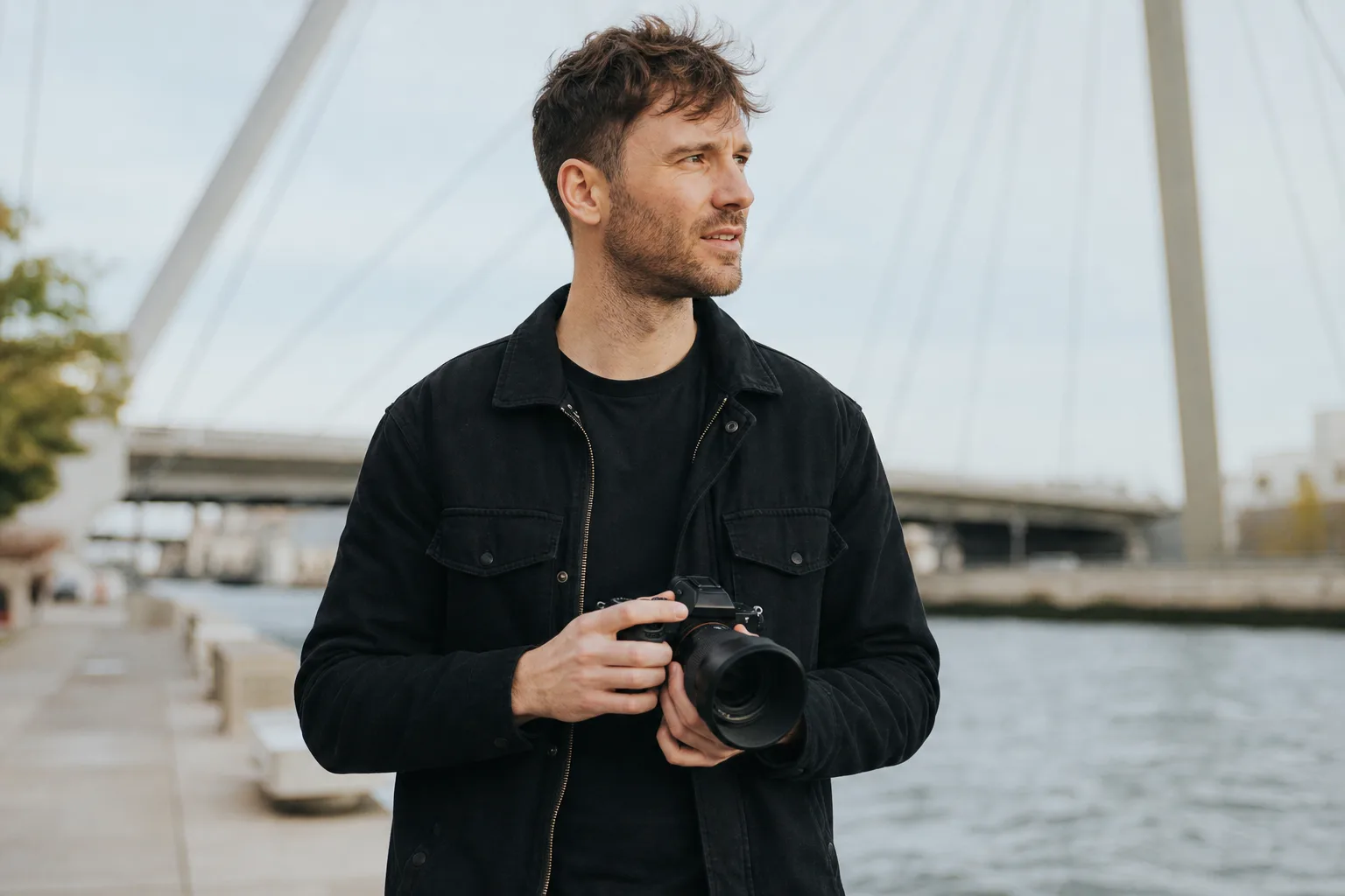 man in black jacket holding camera during daytime