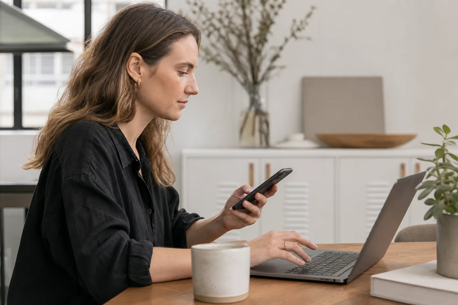 person using both laptop and smartphone