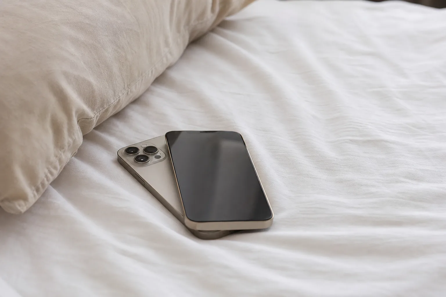 a couple of cell phones sitting on top of a bed