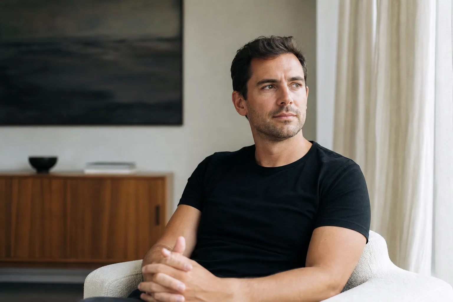 man in black t-shirt sitting on white chair