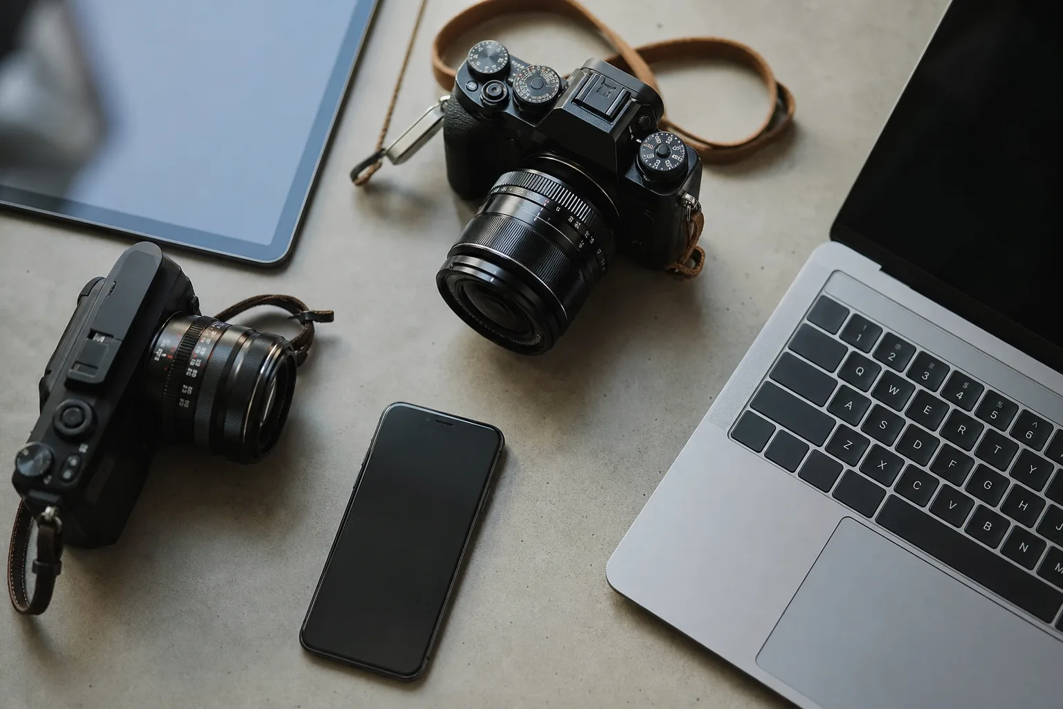 flat view of cameras beside computer tablet and smartphone